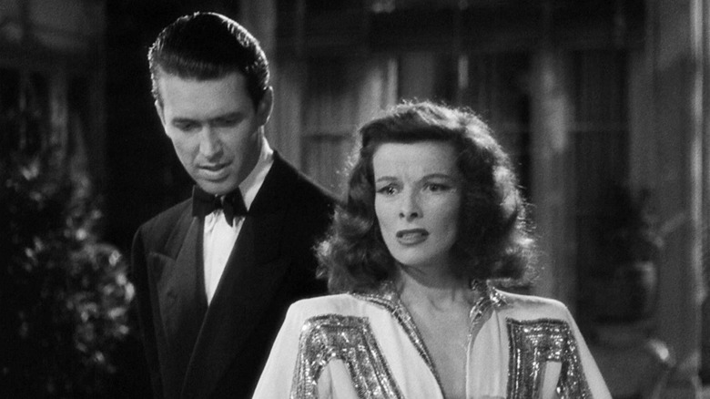 James Stewart's Mike Connor stands behind Katharine Hepburn's Tracy Lord as she looks troubled in The Philadelphia Story