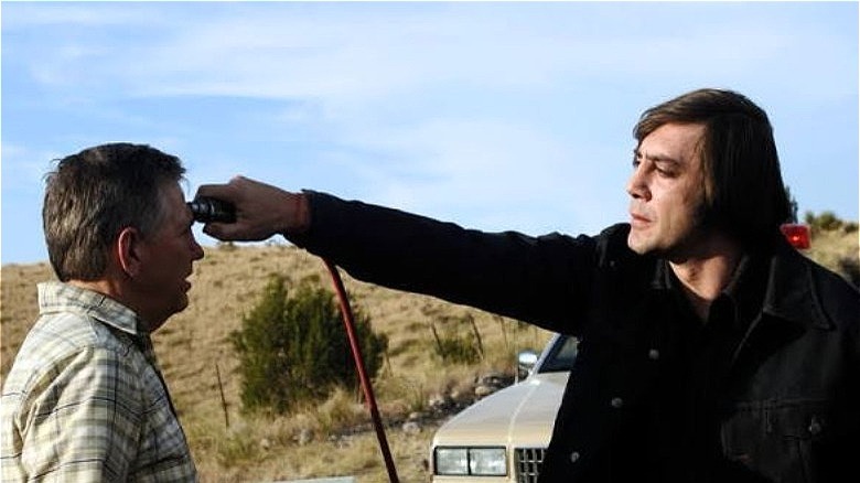 Anton Chigurh points his bolt gun in No Country for Old Men