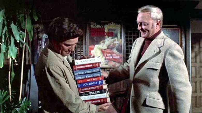 Peter Falk (as Lt. Columbo) holds a large pile of books from an author played by Jack Cassidy