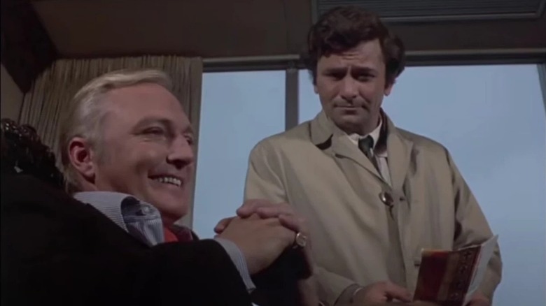 Jack Cassidy smiling and sitting in a chair, as Peter Falk gives him a deadpan look