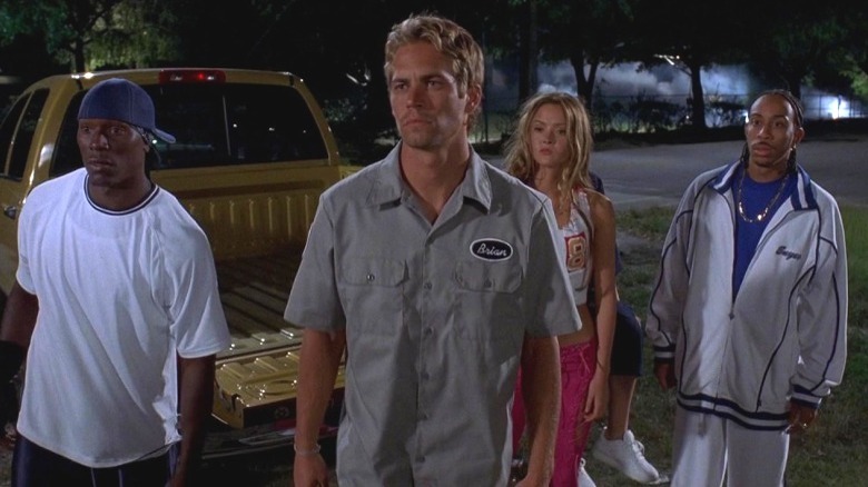 Roman, Brian, Suki, and Tej standing in front of truck in 2 Fast 2 Furious