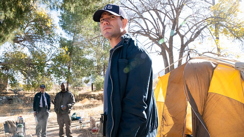 Austin Stowell's Gibbs looks around at a campsite in NCIS: Origins