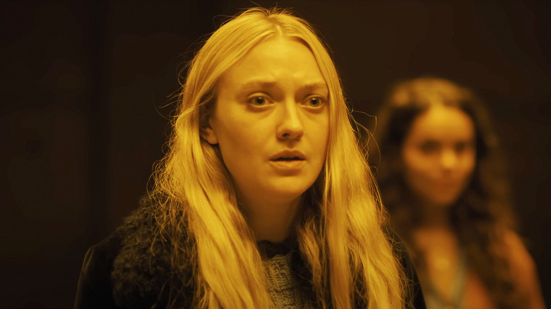 Mina/Lucy de Dakota Fanning parece asustada cuando la luz amarilla la ilumina en The Watchers