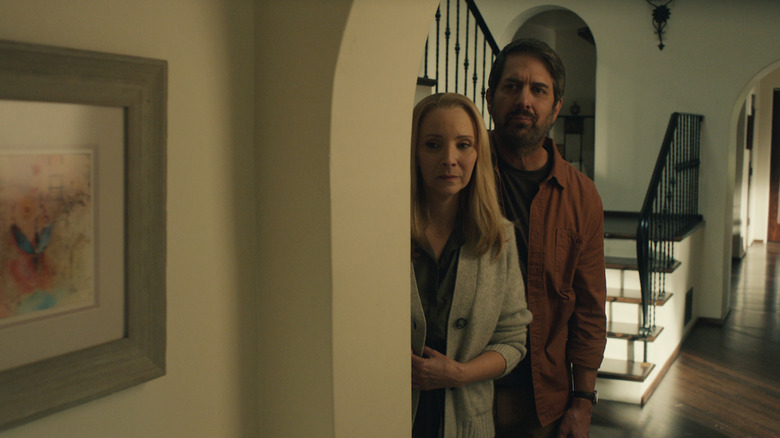 Ray Romano's Paul and Lisa Kudrow 's Lydia stand togeter in the hallway of a home looking down the hall in No Good Deed