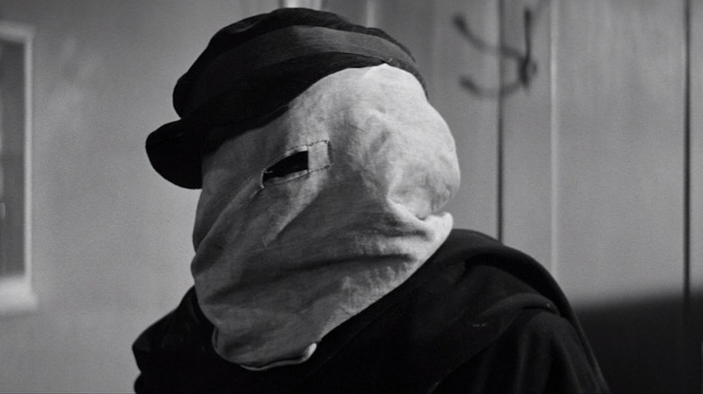 John Hurt as a hooded John Merrick in The Elephant Man