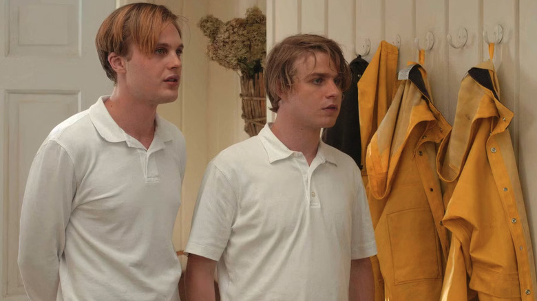 Paul and Peter wearing all white in front of yellow jackets in Funny Games