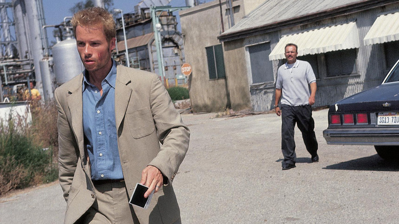 Guy Pearce as Leonard walking angrily away from Joe Pantoliano as Teddy in Memento