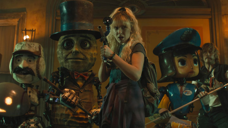 Michelle, wielding a gun-like weapons, standing among mascot robots, also ready for battle, a scene from The Electric State.