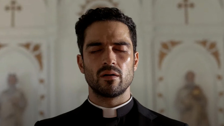 Father Tomas Ortega praying in church