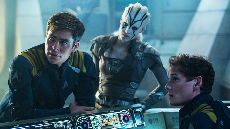 Chris Pine, Sofia Boutella e Anton Yelchin se reúnem em torno de um console em Star Trek Beyond