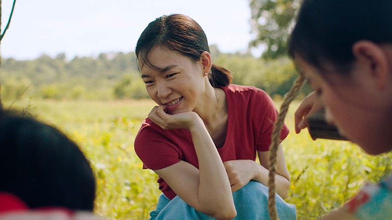 Yan He-ri smiling in a field in Minari