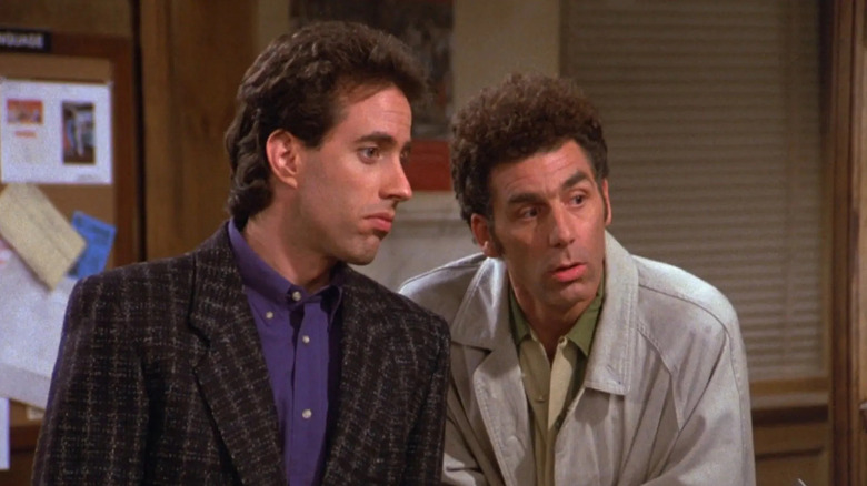 Jerry Seinfeld as Jerry and Michael Richards as Kramer listening intently on Seinfeld