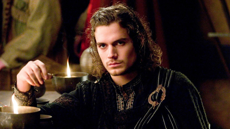 Henry Cavill as Melot sitting at a table in Tristan & Isolde