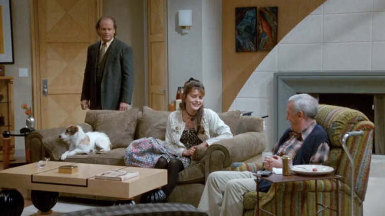 Kelsey Grammer's Frasier Crane, Jane Leeves' Daphne Moon, and John Mahoney's Martin Crane sit in Frasier's living room in Frasier