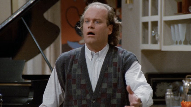 Kelsey Grammer's Frasier Crane stands in his living room in Frasier