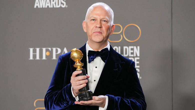 Ryan Murphy holding a Golden Globe