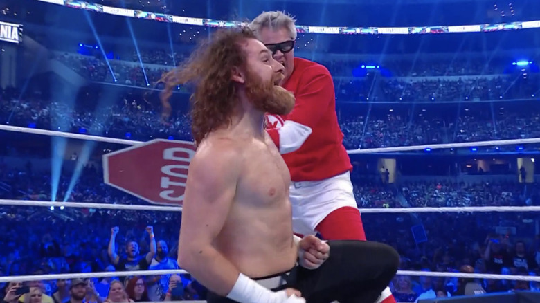 Johnny Knoxville hits Sami Zayn in the back with a stop sign 