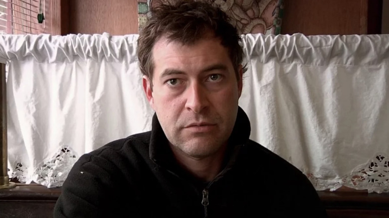 Mark Duplass parece desamparado, mirando a la cámara mientras está sentado en un restaurante de crepes.