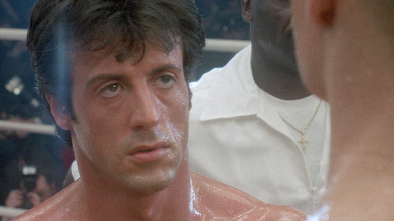 Sylvester Stallone as Rocky looks up warily at Drago in Rocky IV