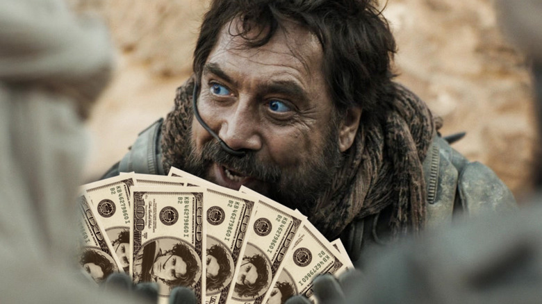 Javier Bardem as Stilgar holding money with Paul's face on it in Dune: Part Two