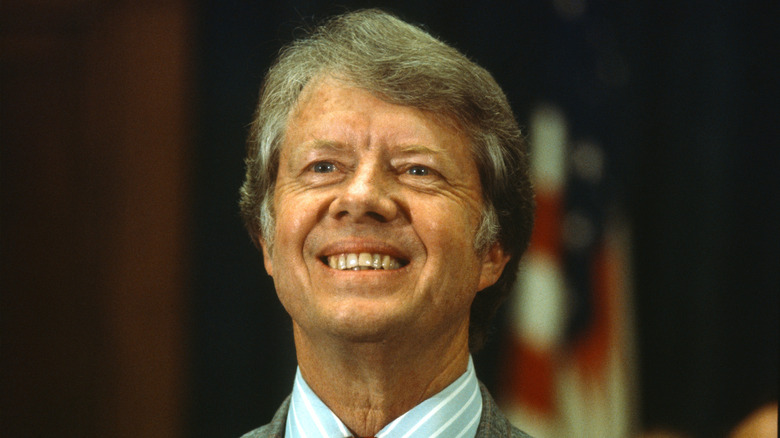 Jimmy Carter wearing a suit and smiling