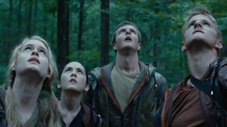 Glimmer, Clove, Cato, and Marvel looking up at Katniss in a tree in The Hunger Games