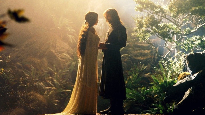 Aragorn y Arwen tomados de la mano en un jardín en La Comunidad del Anillo