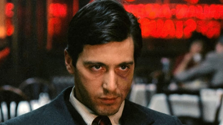 Al Pacino as Michael Corleone, scowling during the restaurant scene in The Godfather