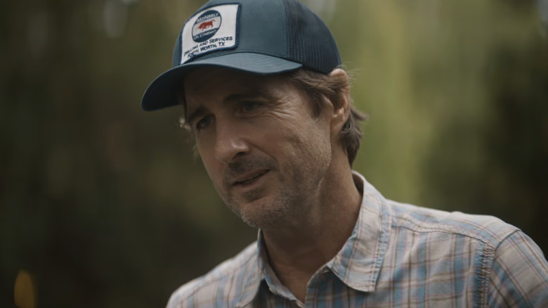 Luke Wilson's Bobby Ratliff stands smiling while wearing a cap in You Gotta Believe