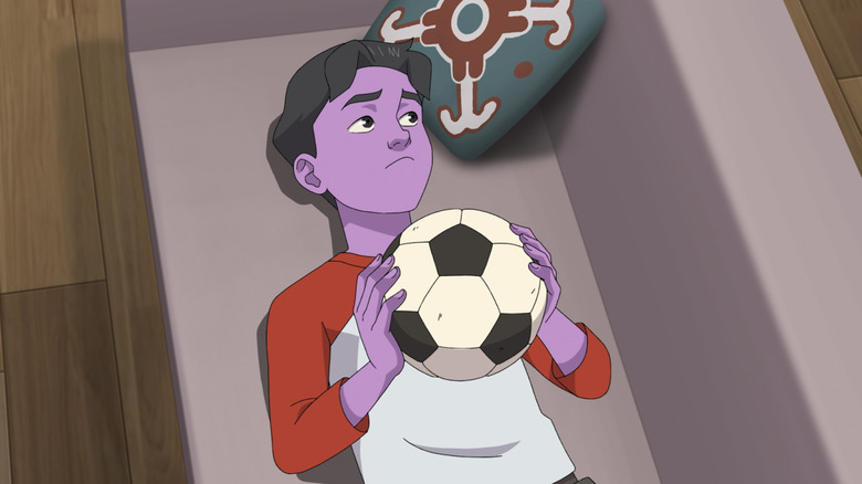 Oliver deitado no sofá jogando com uma bola de futebol em invencível