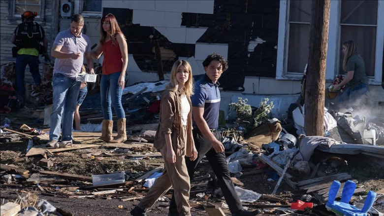 Kate and Javi walking through a destroyed town in Twisters