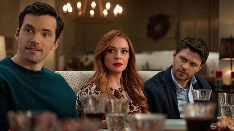 Jon Rudnitsky as Cam, Lindsay Lohan as Avery, and Ian Harding as Logan sitting at the table in Our Little Secret