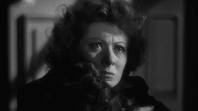 Greer Garson as Kay Miniver looks away while holding someone, tears in her eyes, in Mrs. Miniver