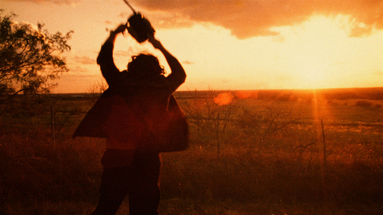 Leatherface, at sunset, swinging his chainsaw above his head