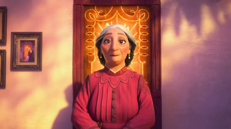 Abuela Alma Madrigal standing in front of a glowing door in Encanto