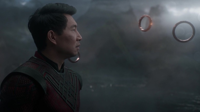 Shang-Chi, looking at floating magical rings.