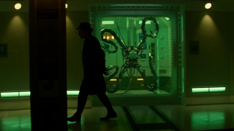 The Gentleman walking past a display case containing the arms of Doctor Octopus in The Amazing Spider-Man 2