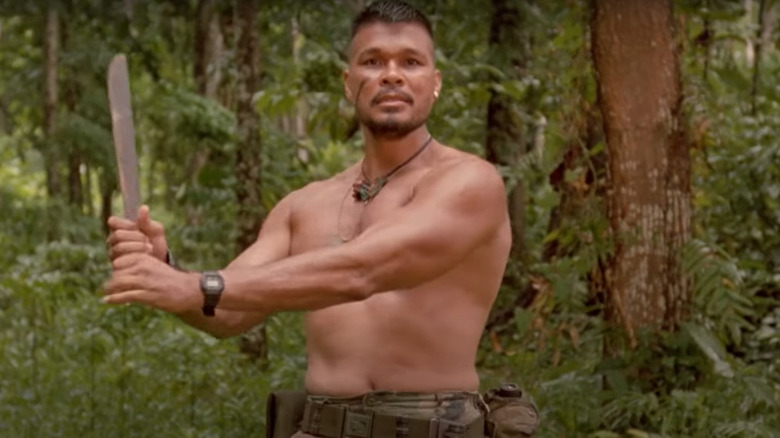 Shirtless man brandishing machete