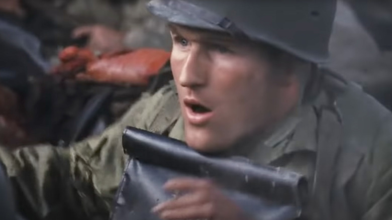 A soldier gets hit in the helmet