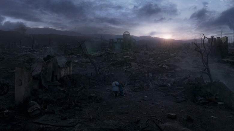 Brian Tyree Henry's Phastos and Salma Hayek's Ajak kneeling amongst the rubble of the A bomb in Eternals