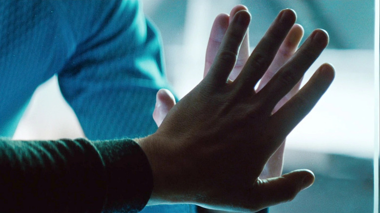 Kirk and Spock touching hands through glass