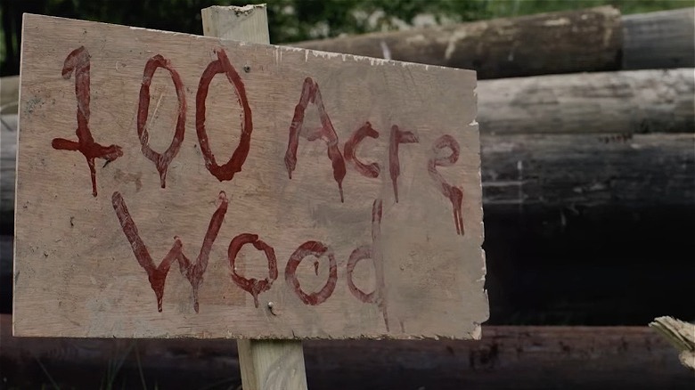 Wooden sign reading "100 Acre Wood" written in blood