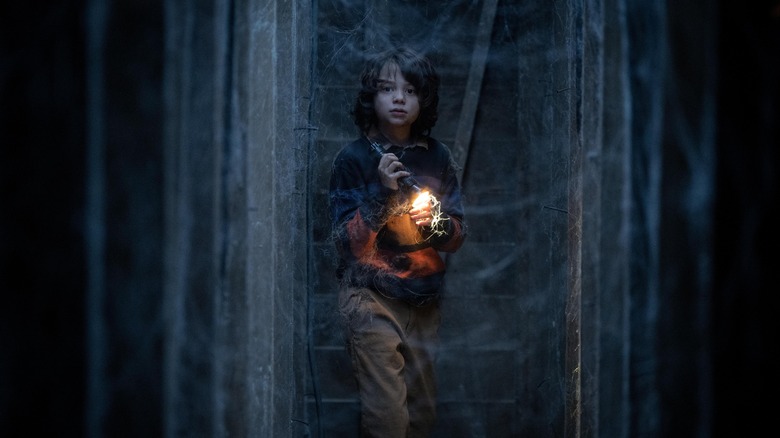 Peter walking through cobwebs with flashlight