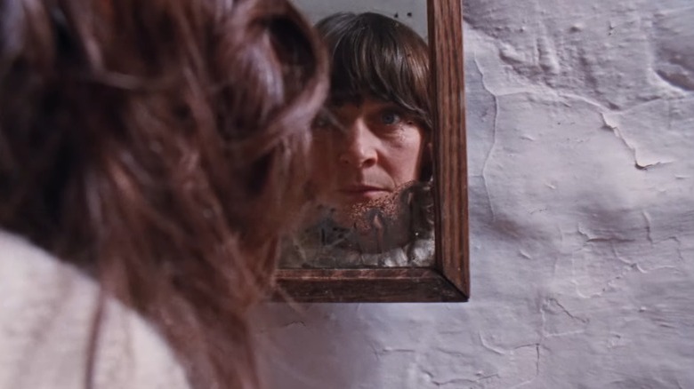 The volunteer looking at herself in the mirror in Enys Men