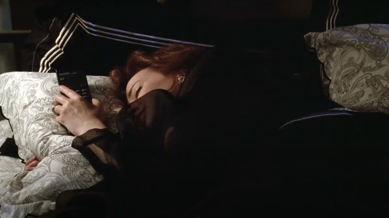 Catherine O'Hara asleep holding a remote control in Beetlejuice