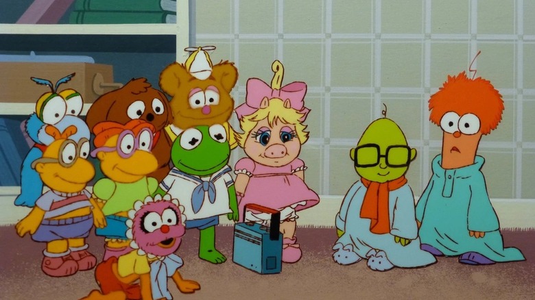 A group of infant Muppets, including Animal, Scooter, Fozzie, Kermit, and Piggy, stand around a tape recorder in the animated TV series 