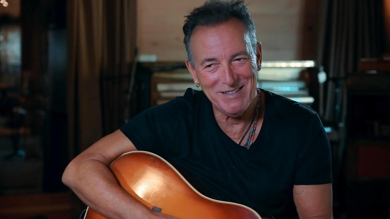 Bruce Springsteen segurando sua guitarra em Stevie Van Zandt: Disciple