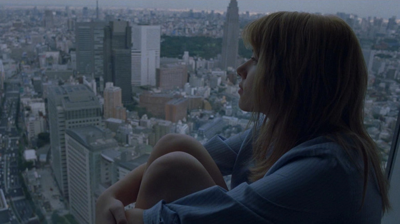  Scarlett Johnasson stares out a hotel window at the city skyline