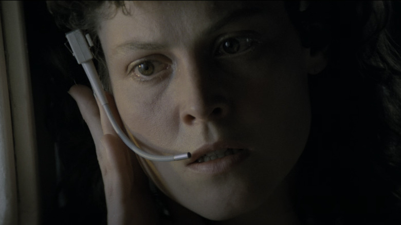 Sigourney Weaver's Ellen Ripley looks concerned as she listens to her headset in Aliens