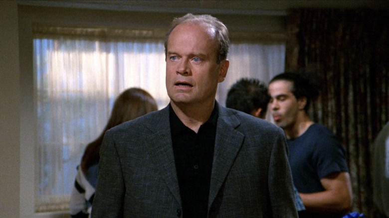 Frasier at a party, looking at something off screen in surprise